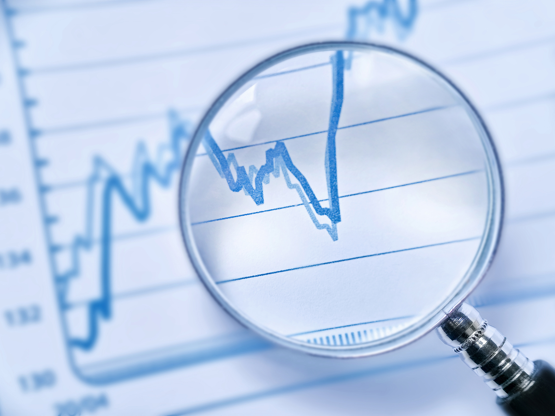 Magnifying glass analysing performance data and trends for commercial building risk management.