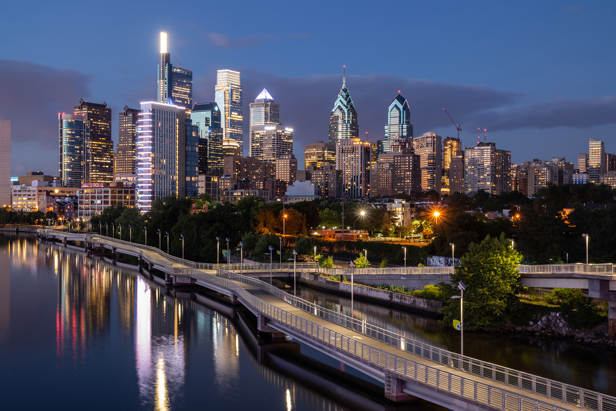 Modern commercial city skyline at dusk with office towers and waterfront infrastructure.