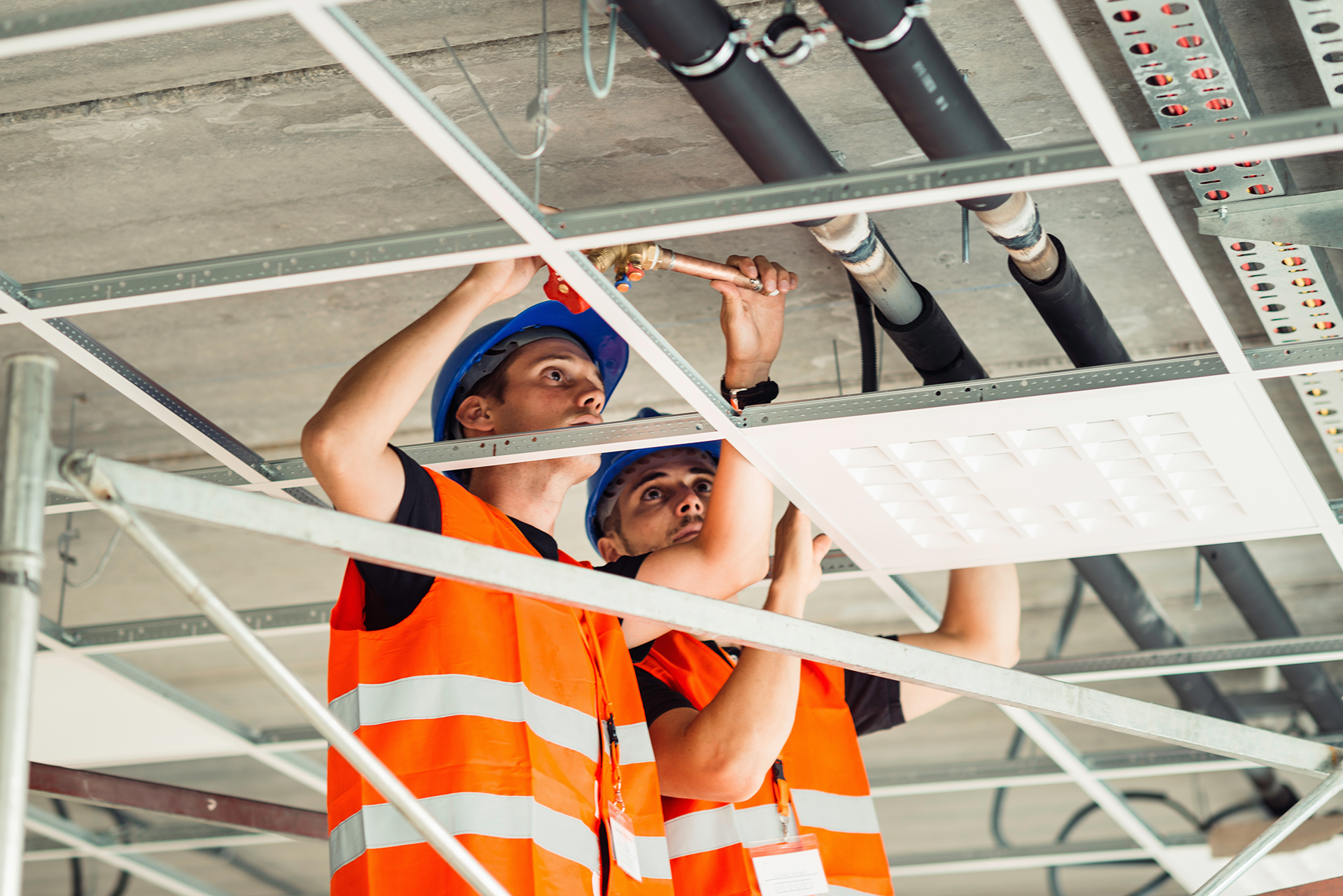 Contractors performing ceiling installation work in a commercial building representing project risk governance and risk management.