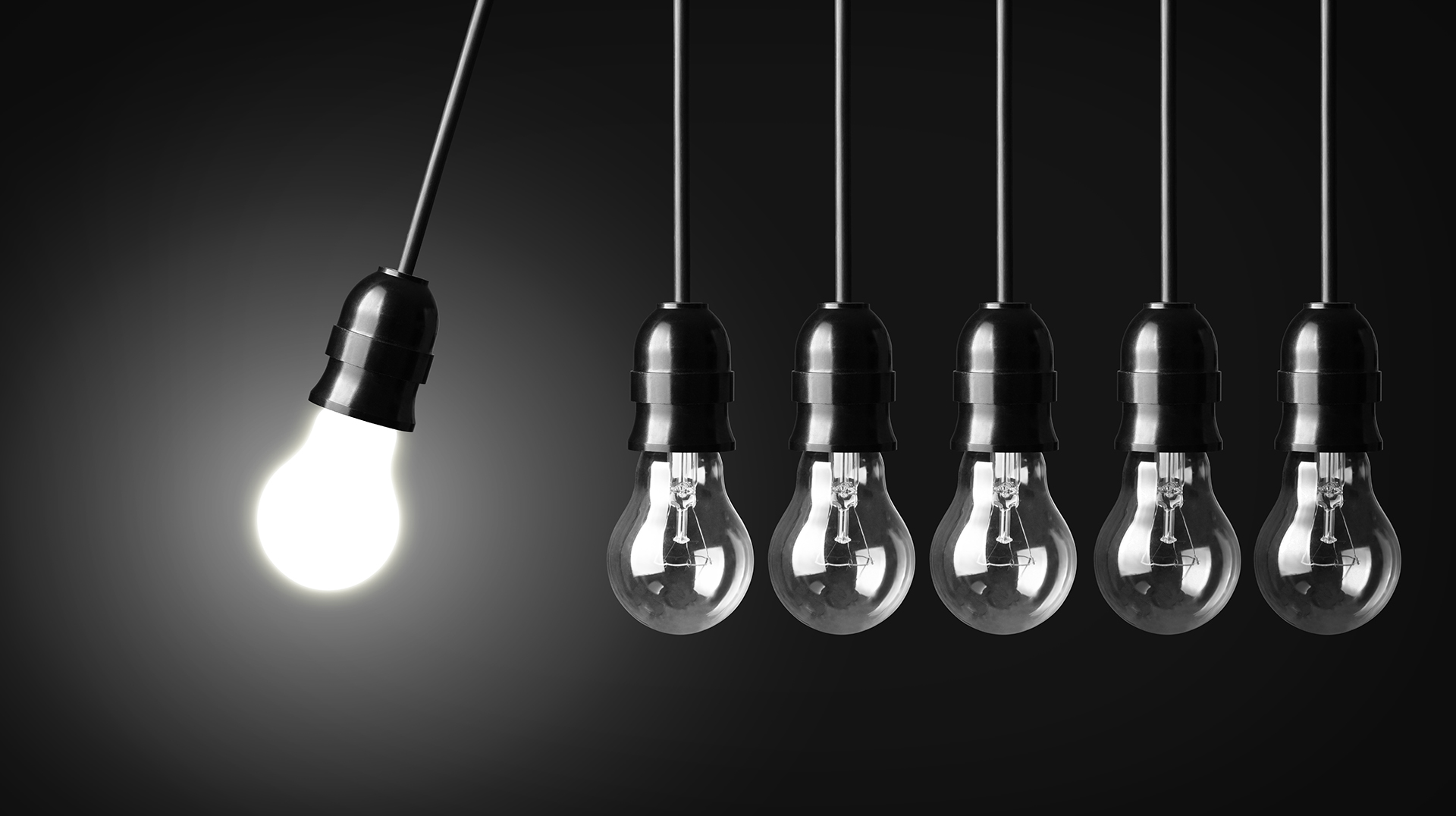 Single illuminated light bulb among unlit bulbs representing project governance, innovation, and building improvement initiatives.
