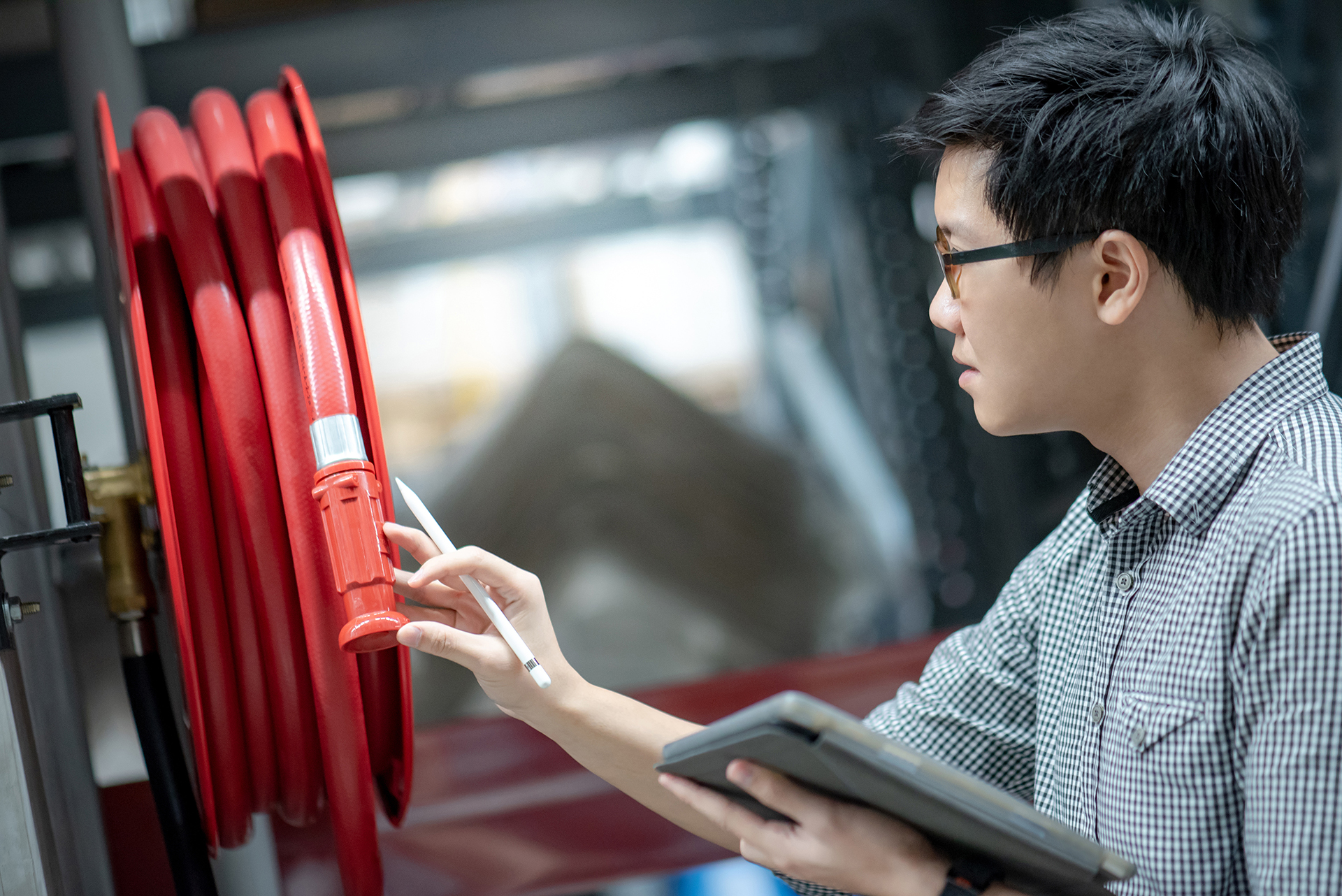 Building professional inspecting fire safety equipment as part of strata governance, compliance management, and risk control.